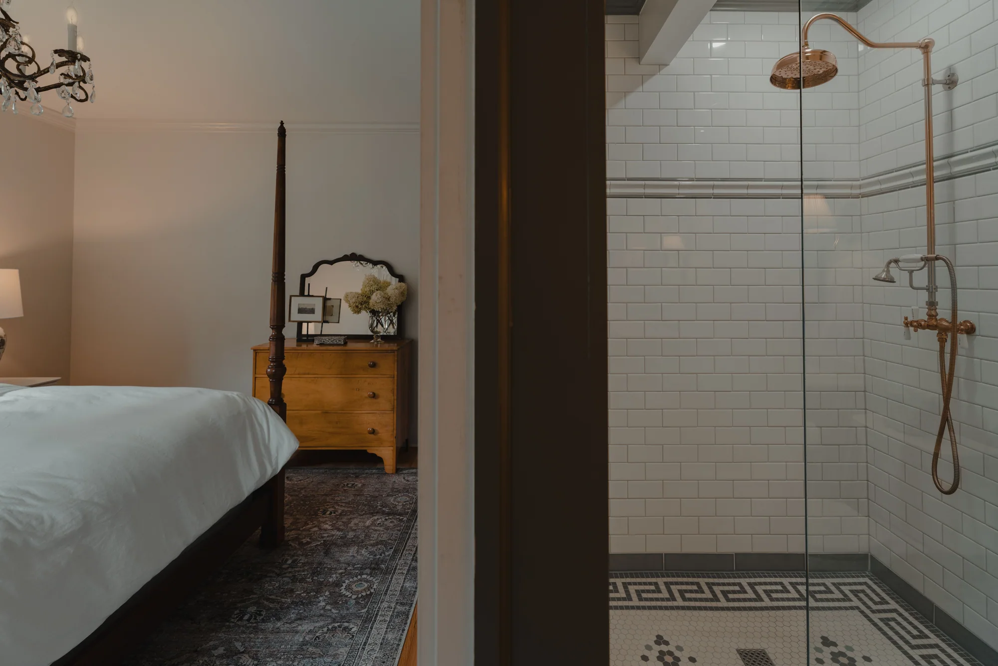 Custom bedroom and tiled shower seen across an interior doorway