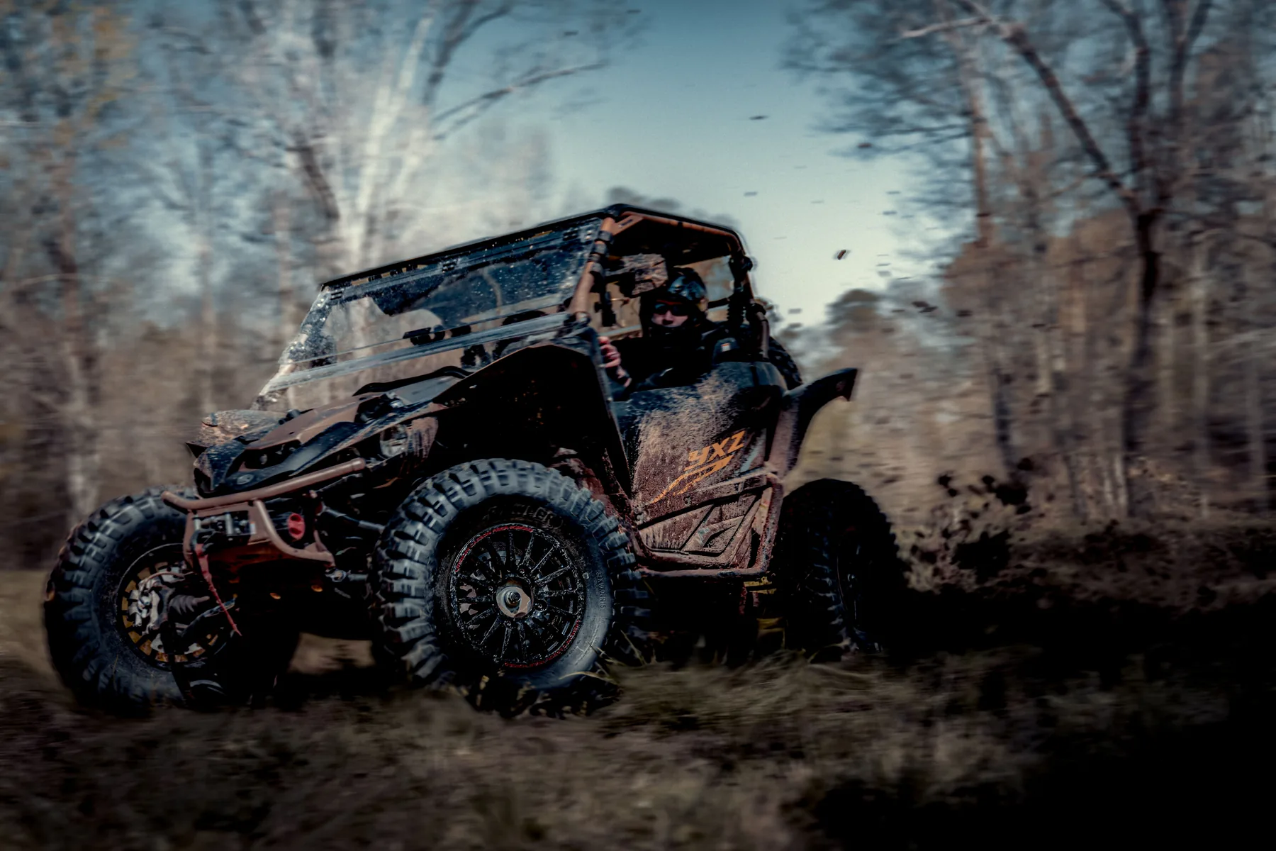Off-road vehicle moving through a wooded trail for a wheel brand campaign