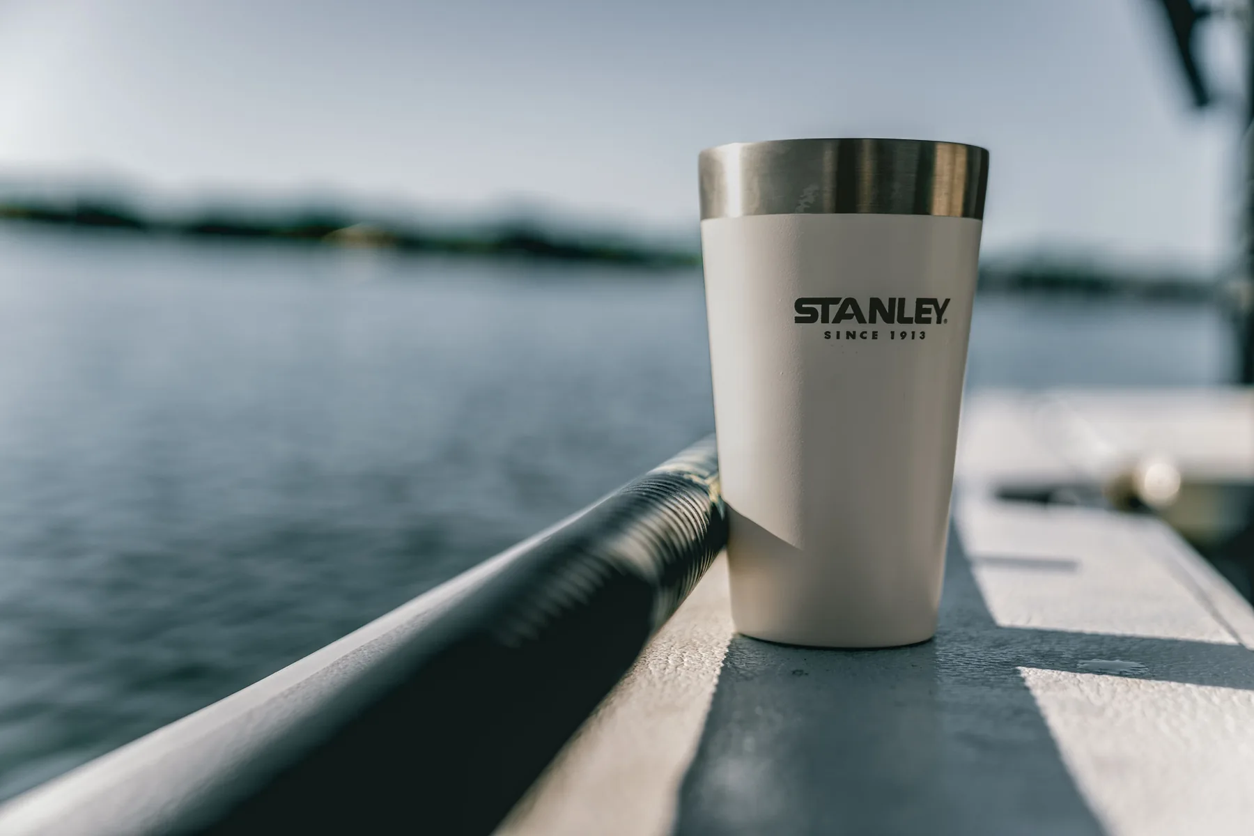 Stanley tumbler photographed on a boat with water in the background