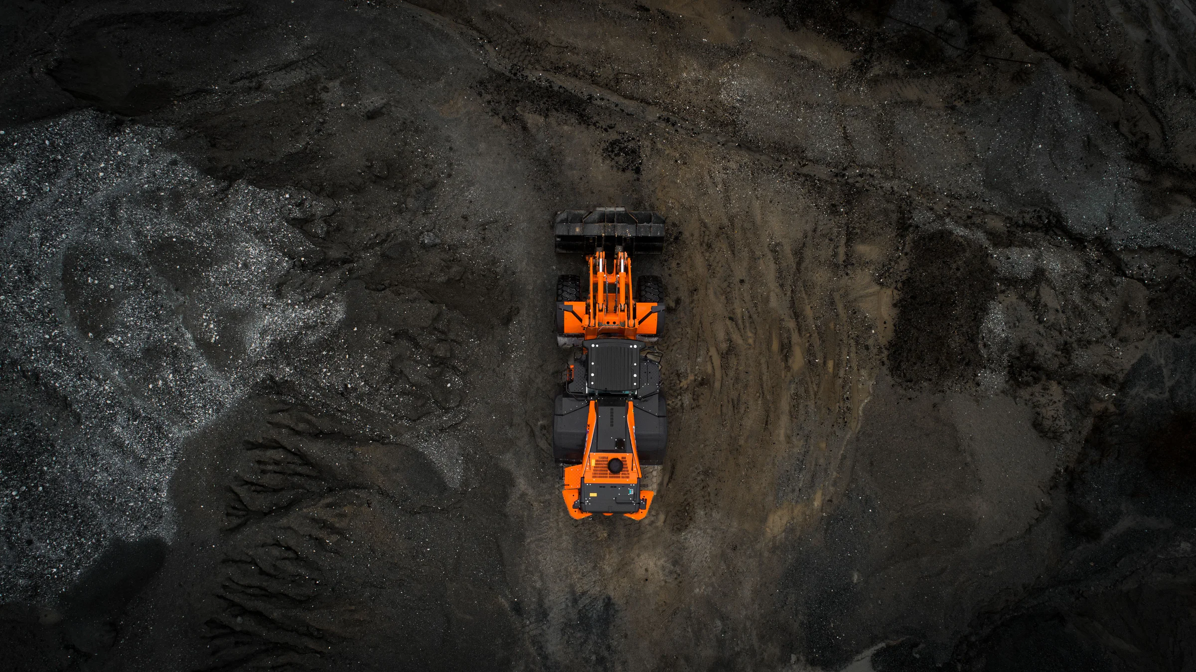 Commercial industrial photography of an orange Hitachi loader