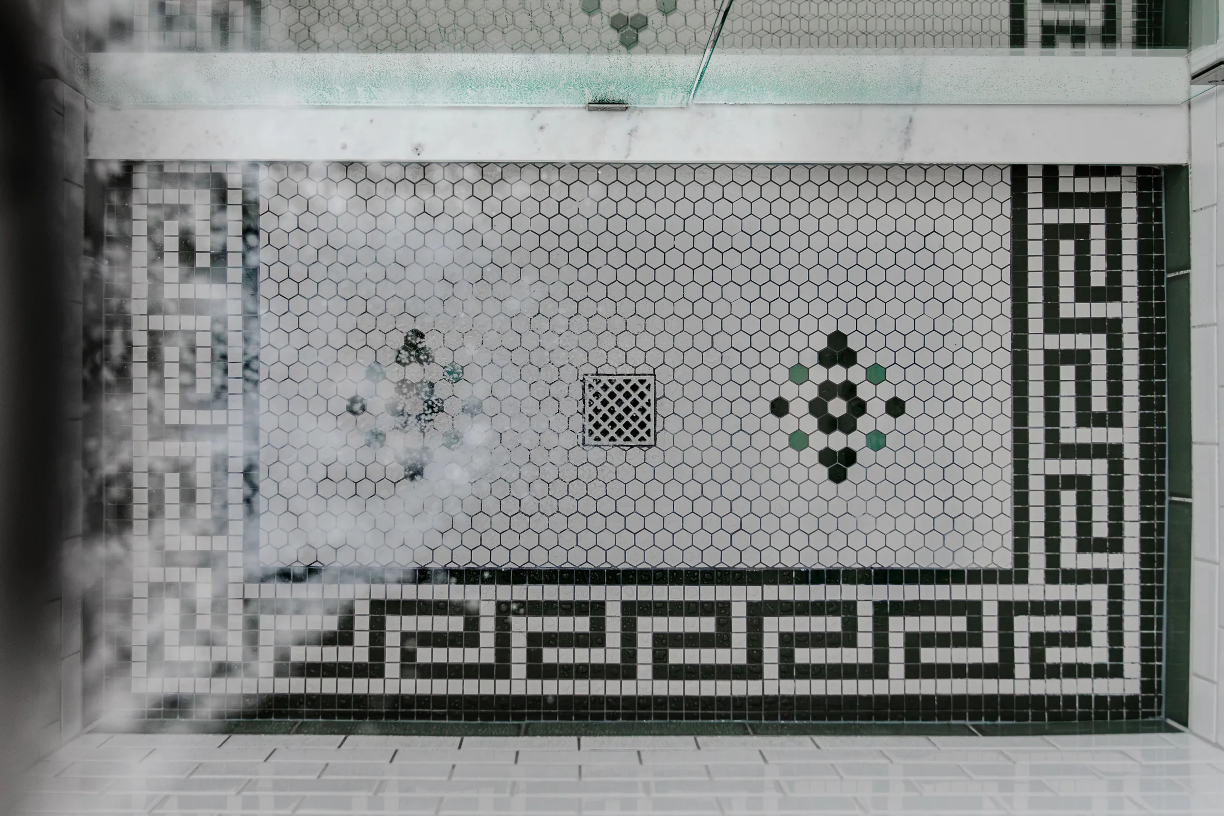 Interior design photography of a custom shower with geometric mosaic tile